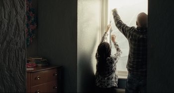 Movie still from “I, Daniel Blake” (2016), directed by Ken Loach – Two people are looking out of a window; Medium shot, Low angle