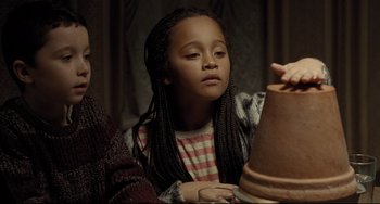 Movie still from “I, Daniel Blake” (2016), directed by Ken Loach – A young girl is looking at a clay pot; Close Up shot, High angle
