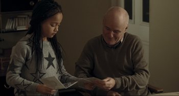 Movie still from “I, Daniel Blake” (2016), directed by Ken Loach – An older man sitting next to a young girl; Medium shot, Over the shoulder angle