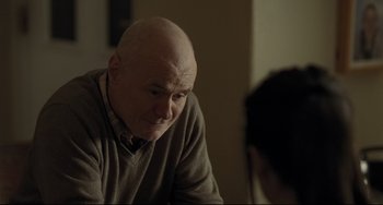 Movie still from “I, Daniel Blake” (2016), directed by Ken Loach – An older man sitting in front of a woman; Close Up shot, Over the shoulder angle