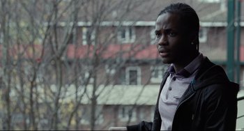Movie still from “I, Daniel Blake” (2016), directed by Ken Loach – A man standing in front of a building with trees in the background; Close Up shot, Over the shoulder angle