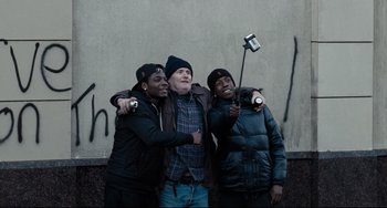 Movie still from “I, Daniel Blake” (2016), directed by Ken Loach – A group of young men standing next to each other; Medium shot, High angle