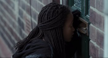Movie still from “I, Daniel Blake” (2016), directed by Ken Loach – A woman with long braids leaning against a window; Close Up shot, Over the shoulder angle