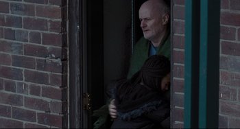 Movie still from “I, Daniel Blake” (2016), directed by Ken Loach – A man and a woman looking out of a window; Medium shot, Over the shoulder angle