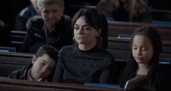 Movie still from “I, Daniel Blake” (2016), directed by Ken Loach – A woman sitting in a pew with a young boy; Close Up shot, Over the shoulder angle