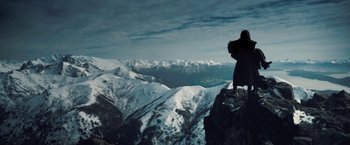 Movie still from “I, Frankenstein” (2014), directed by Stuart Beattie – A person standing on top of a mountain looking at the sky; Extreme Wide shot, Low angle