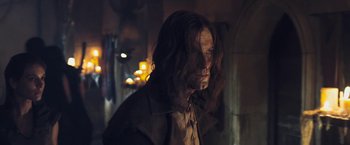 Movie still from “I, Frankenstein” (2014), directed by Stuart Beattie – A man with long hair is standing in a dark room; Medium shot, Low angle