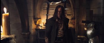 Movie still from “I, Frankenstein” (2014), directed by Stuart Beattie – A man with long black hair standing in front of a fireplace; Medium shot, Low angle