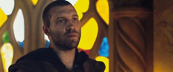 Movie still from “I, Frankenstein” (2014), directed by Stuart Beattie – A man standing in front of a stained - glass window; Close Up shot, Low angle