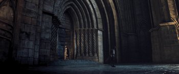 Movie still from “I, Frankenstein” (2014), directed by Stuart Beattie – A person walking in a dark room with a stone arch; Extreme Wide shot, Low angle