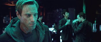 Movie still from “I, Frankenstein” (2014), directed by Stuart Beattie – A man in a dark room holding a drink; Close Up shot, Over the shoulder angle