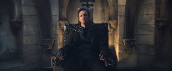 Movie still from “I, Frankenstein” (2014), directed by Stuart Beattie – A man sitting in a chair with chains around his neck; Medium shot, Low angle