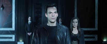 Movie still from “I, Frankenstein” (2014), directed by Stuart Beattie – A man in a leather jacket standing next to a woman in a black dress; Medium shot, Low angle