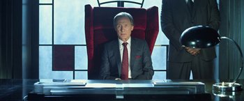Movie still from “I, Frankenstein” (2014), directed by Stuart Beattie – A man in a suit and tie sitting at a desk; Medium shot, Low angle