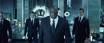 Movie still from “I, Frankenstein” (2014), directed by Stuart Beattie – A man in a suit and tie standing next to another man in a suit and tie; Medium shot, Low angle