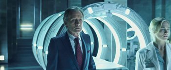 Movie still from “I, Frankenstein” (2014), directed by Stuart Beattie – A man wearing a suit and tie standing in a room; Medium shot, Low angle