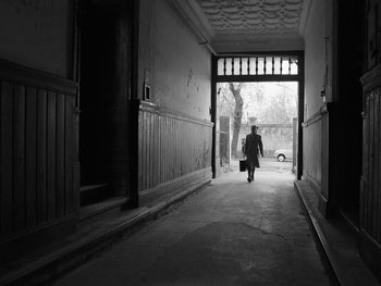 Movie still from “Ida” (2013), directed by Pawel Pawlikowski – A man walking down a street holding a suitcase; Wide shot, Low angle