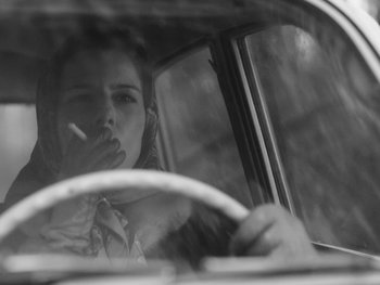 Movie still from “Ida” (2013), directed by Pawel Pawlikowski – A woman smoking a cigarette while driving a car; Close Up shot, Over the shoulder angle