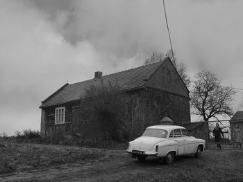 Movie still from “Ida” (2013), directed by Pawel Pawlikowski – An old car parked in front of an old house; Extreme Wide shot, Low angle