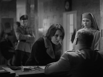 Movie still from “Ida” (2013), directed by Pawel Pawlikowski – A woman sitting at a table talking to a man; Medium shot, Over the shoulder angle