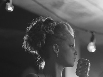 Movie still from “Ida” (2013), directed by Pawel Pawlikowski – A woman with blonde hair is singing into a microphone; Close Up shot, Low angle