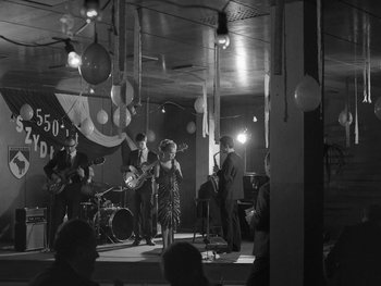 Movie still from “Ida” (2013), directed by Pawel Pawlikowski – A black and white photo of a group of people on stage; Wide shot, Low angle
