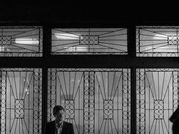 Movie still from “Ida” (2013), directed by Pawel Pawlikowski – A man standing in front of an ornate glass window; Wide shot, Low angle