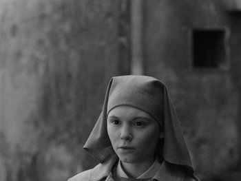 Movie still from “Ida” (2013), directed by Pawel Pawlikowski – A young woman wearing a nun's hat and looking at the camera; Close Up shot, Low angle