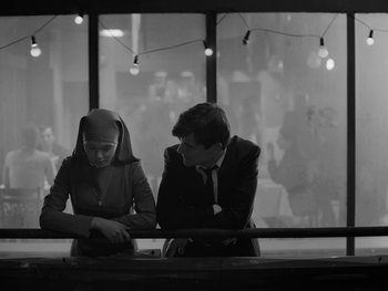 Movie still from “Ida” (2013), directed by Pawel Pawlikowski – A man and a woman sitting at a table in front of a window; Medium shot, Over the shoulder angle