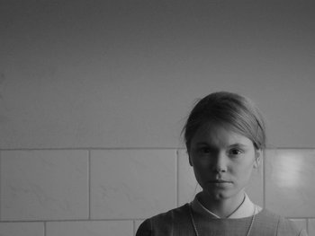 Movie still from “Ida” (2013), directed by Pawel Pawlikowski – A young woman is standing in front of a white wall; Close Up shot, Low angle
