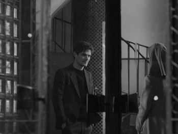 Movie still from “Ida” (2013), directed by Pawel Pawlikowski – A black and white photo of a man in a suit; Medium shot, Over the shoulder angle