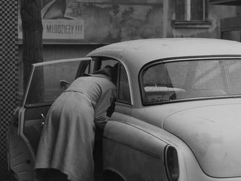 Movie still from “Ida” (2013), directed by Pawel Pawlikowski – An older woman leaning on the door of an old car; Medium shot, High angle