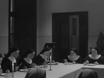 Movie still from “Ida” (2013), directed by Pawel Pawlikowski – A group of nuns sitting at a table with plates of food in front of them; Wide shot, High angle