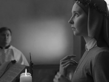 Movie still from “Ida” (2013), directed by Pawel Pawlikowski – A woman in a veil looking at a lit candle; Close Up shot, Over the shoulder angle