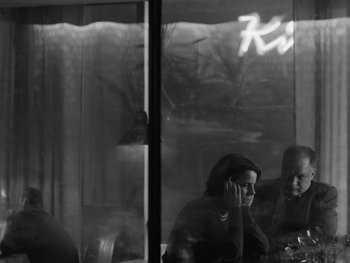 Movie still from “Ida” (2013), directed by Pawel Pawlikowski – Two people sitting at a table in front of a window; Medium shot, Over the shoulder angle