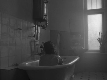 Movie still from “Ida” (2013), directed by Pawel Pawlikowski – A woman sitting in a bath tub in a bathroom; Wide shot, High angle