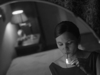 Movie still from “Ida” (2013), directed by Pawel Pawlikowski – A woman is holding a light in her mouth; Close Up shot, Over the shoulder angle