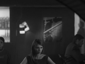 Movie still from “Ida” (2013), directed by Pawel Pawlikowski – A black and white photo of a woman in a dark room; Medium shot, Over the shoulder angle
