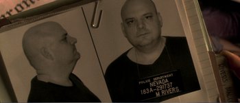 Movie still from “Identity” (2003), directed by James Mangold – An old photo of a man in a black shirt; Close Up shot, Overhead angle