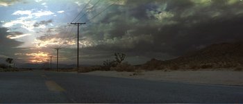 Movie still from “Identity” (2003), directed by James Mangold – A cloudy sky over a road with power lines; Extreme Wide shot, Low angle
