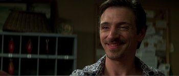 Movie still from “Identity” (2003), directed by James Mangold – A person smiling for the camera; Close Up shot, Over the shoulder angle