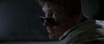 Movie still from “Identity” (2003), directed by James Mangold – A person wearing a pair of sunglasses; Close Up shot, Over the shoulder angle