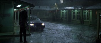 Movie still from “Identity” (2003), directed by James Mangold – A car parked in the middle of the street in the rain; Extreme Wide shot, High angle