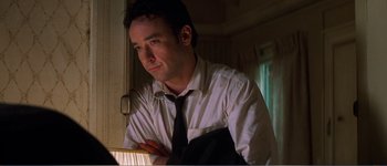Movie still from “Identity” (2003), directed by James Mangold – A man in a white dress shirt and black neck tie; Close Up shot, Low angle