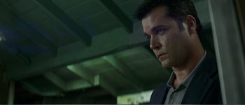 Movie still from “Identity” (2003), directed by James Mangold – A person wearing a suit and tie; Close Up shot, Low angle