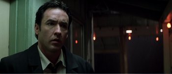 Movie still from “Identity” (2003), directed by James Mangold – A person wearing a suit and tie; Close Up shot, Low angle