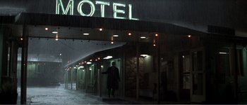 Movie still from “Identity” (2003), directed by James Mangold – A man walking in the rain outside of a hotel; Wide shot, Low angle