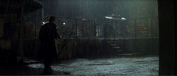 Movie still from “Identity” (2003), directed by James Mangold – A person holding a umbrella in the rain; Wide shot, High angle