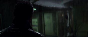 Movie still from “Identity” (2003), directed by James Mangold – A man standing in the dark looking out a window; Close Up shot, Over the shoulder angle