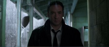 Movie still from “Identity” (2003), directed by James Mangold – A man wearing a black jacket and a tie; Close Up shot, Low angle